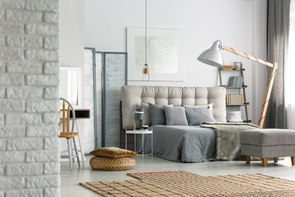 Cozy grey bedroom in modern loft with white brick wall