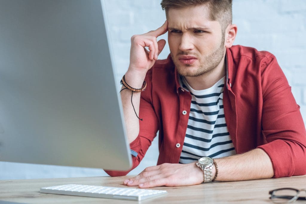 Confused man looking at computer screen