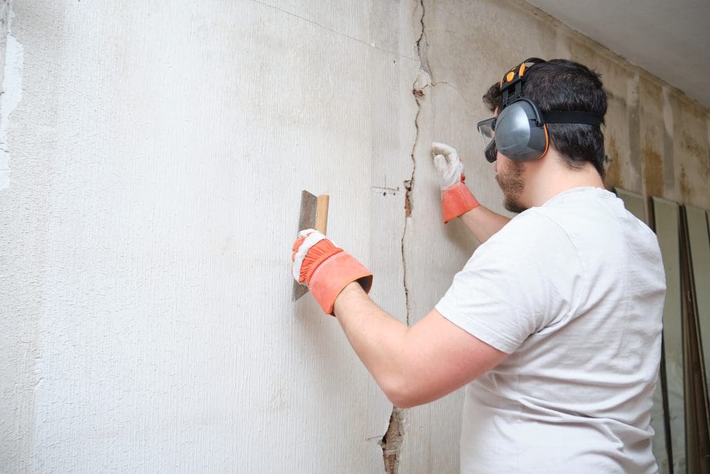 Construction worker repairing a cracked wall.