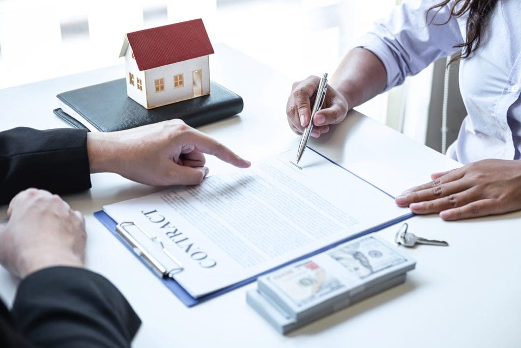 Real estate agent reviewing contract with buyer, the real timeline to buy a house. 