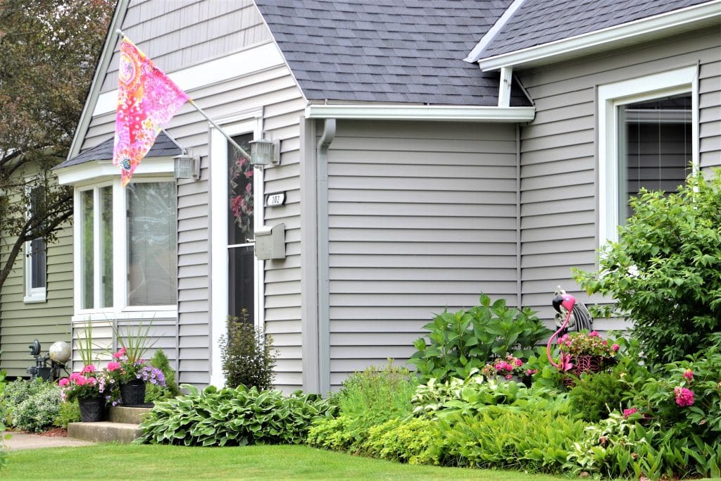 Gray house with landscaped flower beds