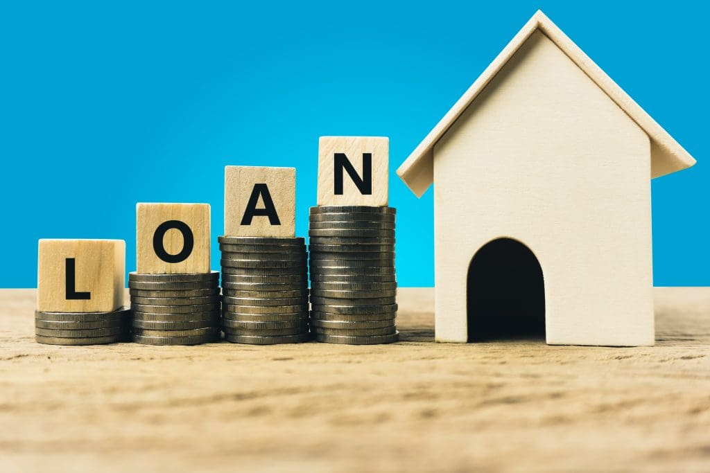 FHA loan closing costs.  Wooden block letters spelling loan on top of stacked coins 