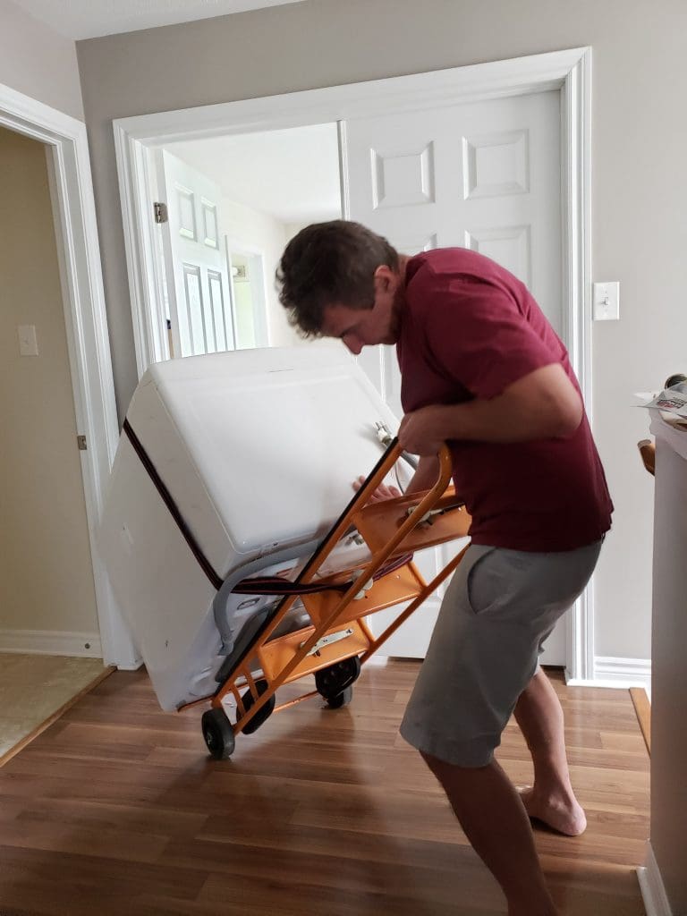 Man moving heavy appliance.  