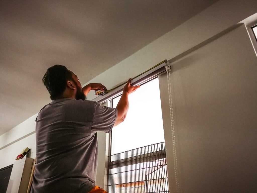 Man installing flinds on window, DIY project