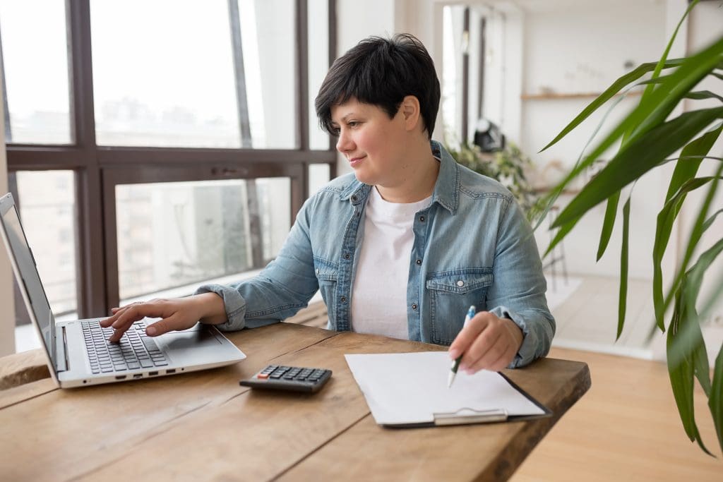 Woman using laptop and online tools to calculate.