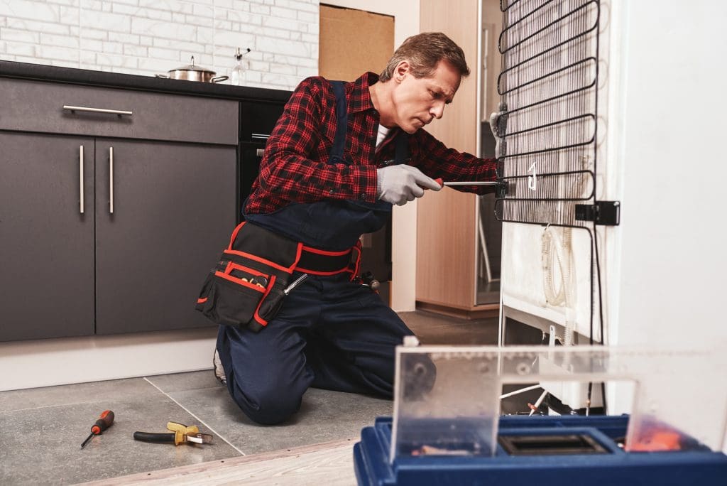 New refrigerator installation. Professional male technician installing refrigerator