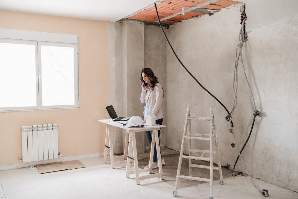 Professional confident architect woman in construction site working on blueprints. Home renovation