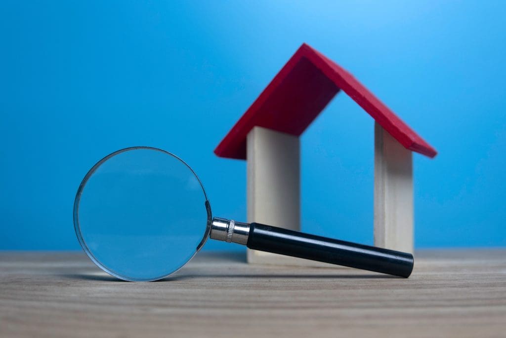 wooden house with magnifying glass