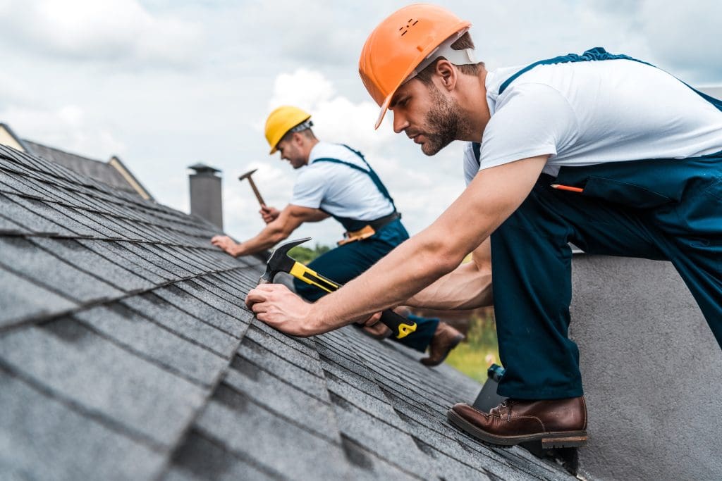 Two men repairing a roof.
