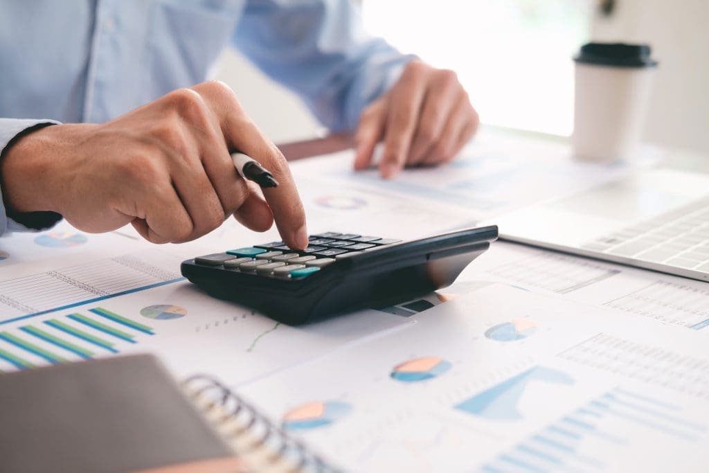 What Are Closing Costs When Buying a Home?  Photo of man using calculator to determine closing costs