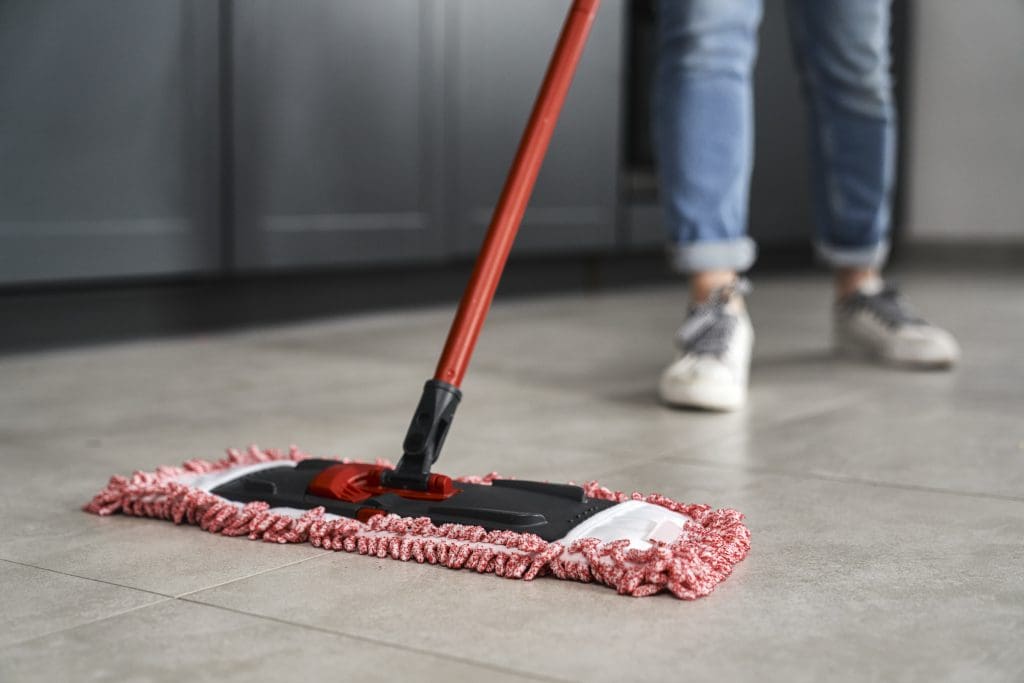 How to Prevent Pest Infestations in Your Home.  Photo of woman mopping floor
