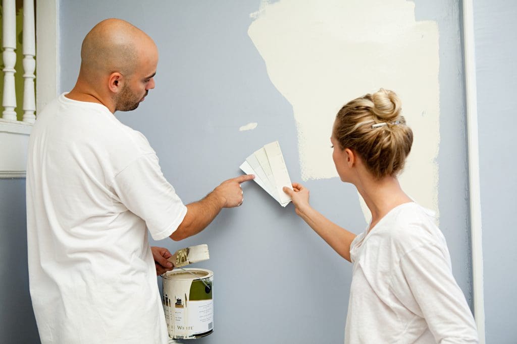 How to Choose the Right Paint Colors for Your Home.  Couple looking at paint swatches