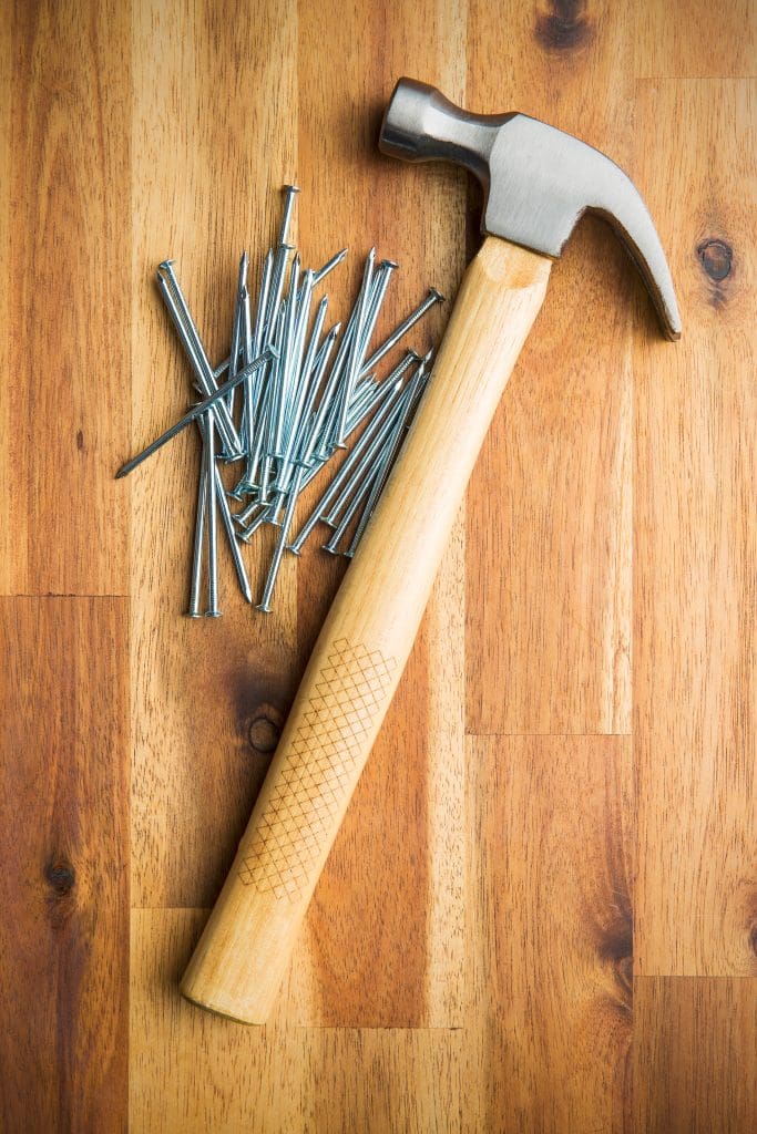 New Homeowner?  10 Must-Have Tools for Home Maintenance.  Hammer and nails on wooden table