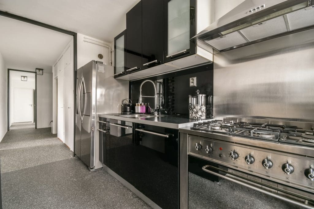 Kitchen in dark colors with modern appliances and flooring.  Concept of home renovations.