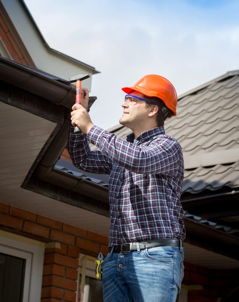 10 Essential Home Maintenance Tips for Homeowners.  Man repairing roof